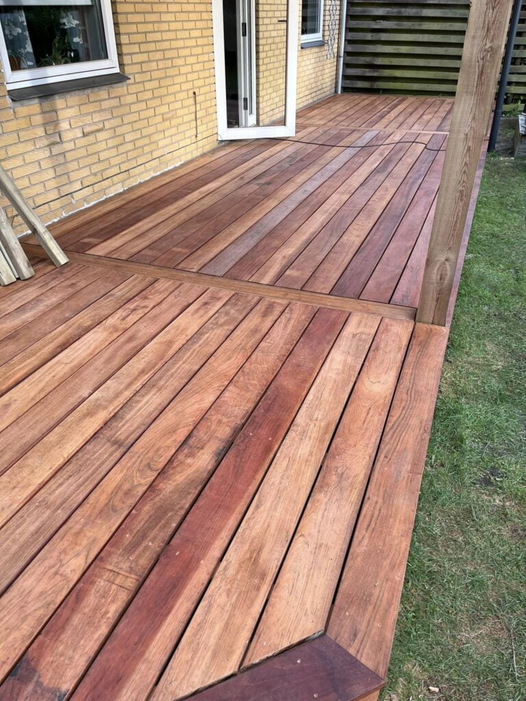 Nybygget træterrasse ved gul murstenshus